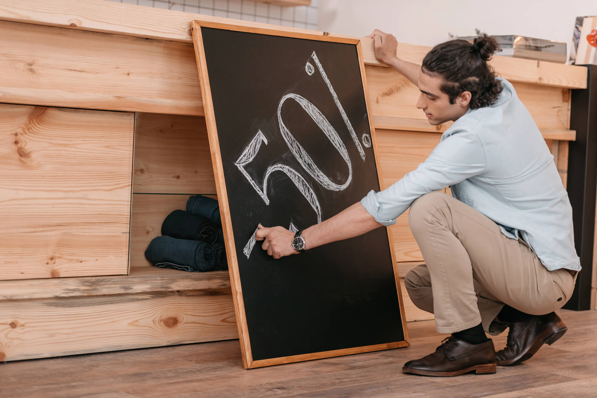 salesman writing -50% on chalkboard