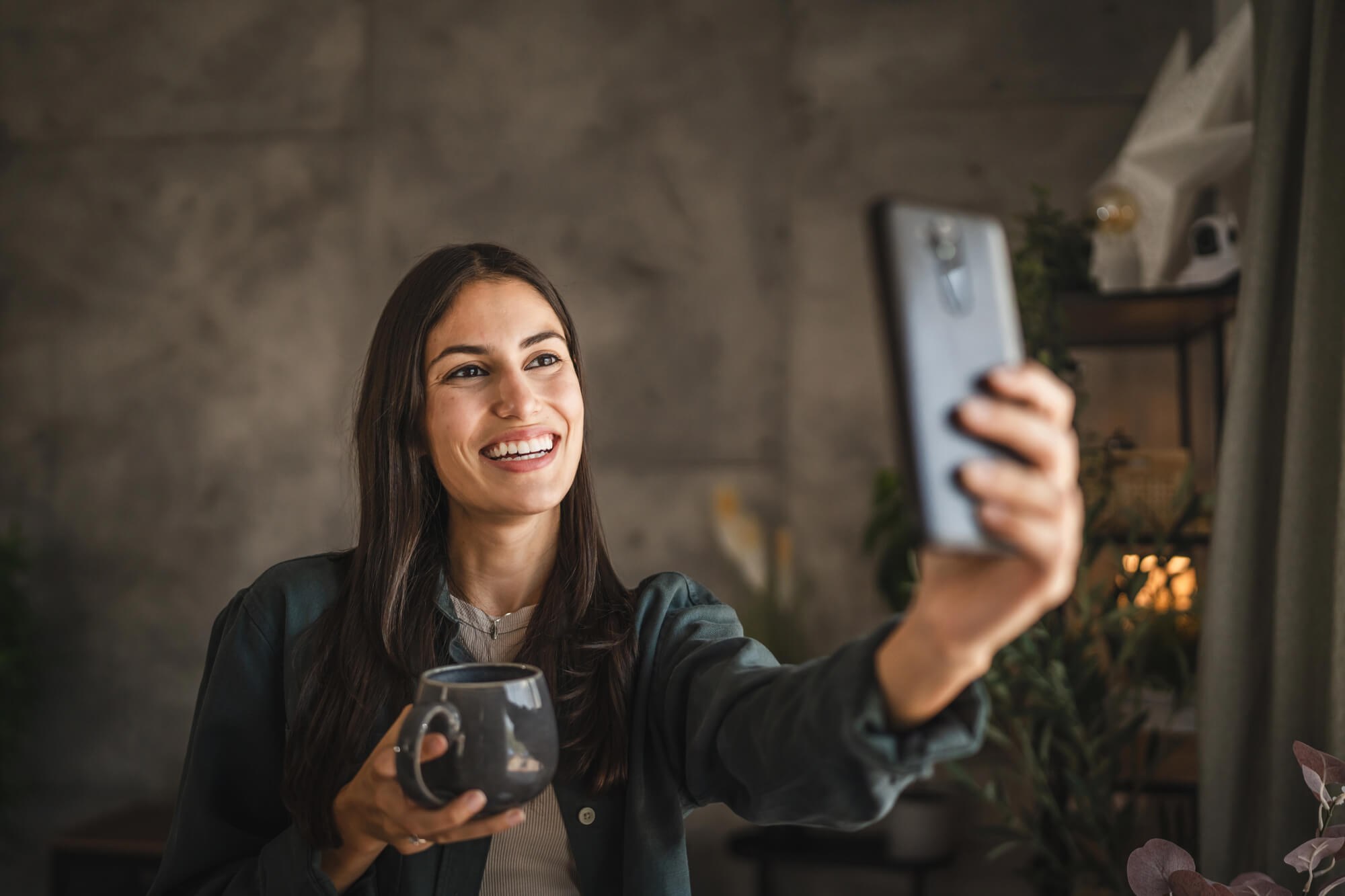 young woman taking a selfie while posing with a drink 