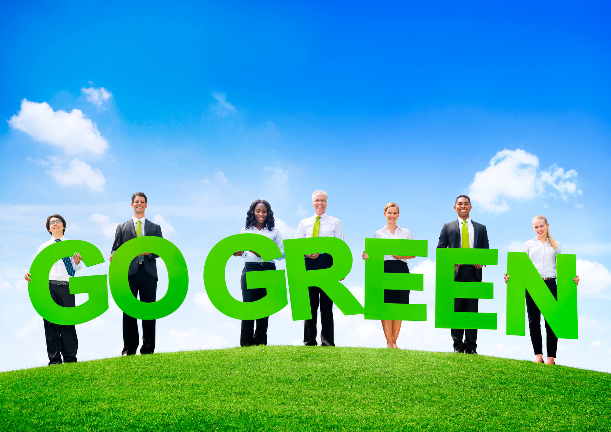 business people each holding a letter to form the sentence 'go green'