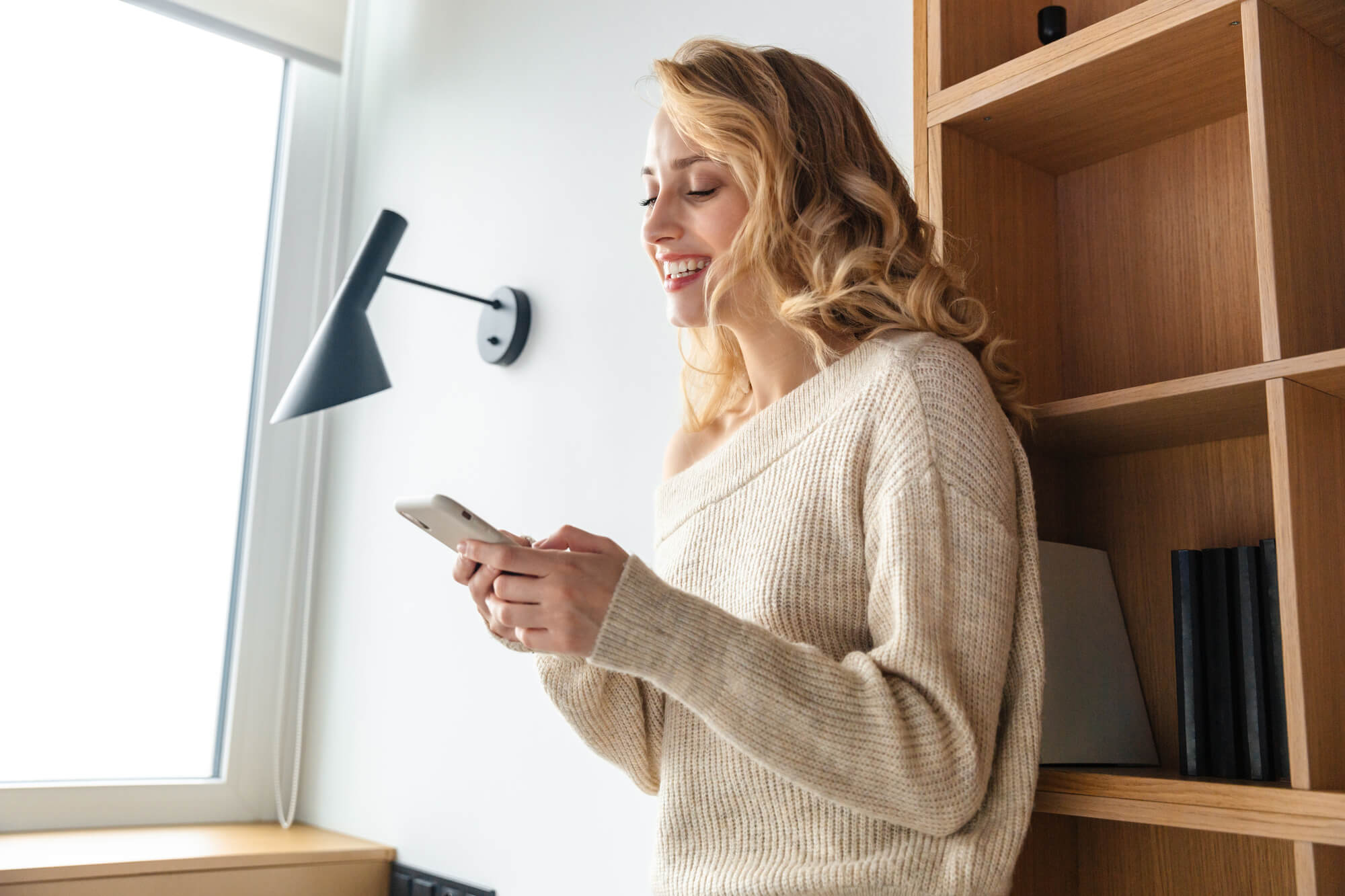 woman smiling while browsing on her phone