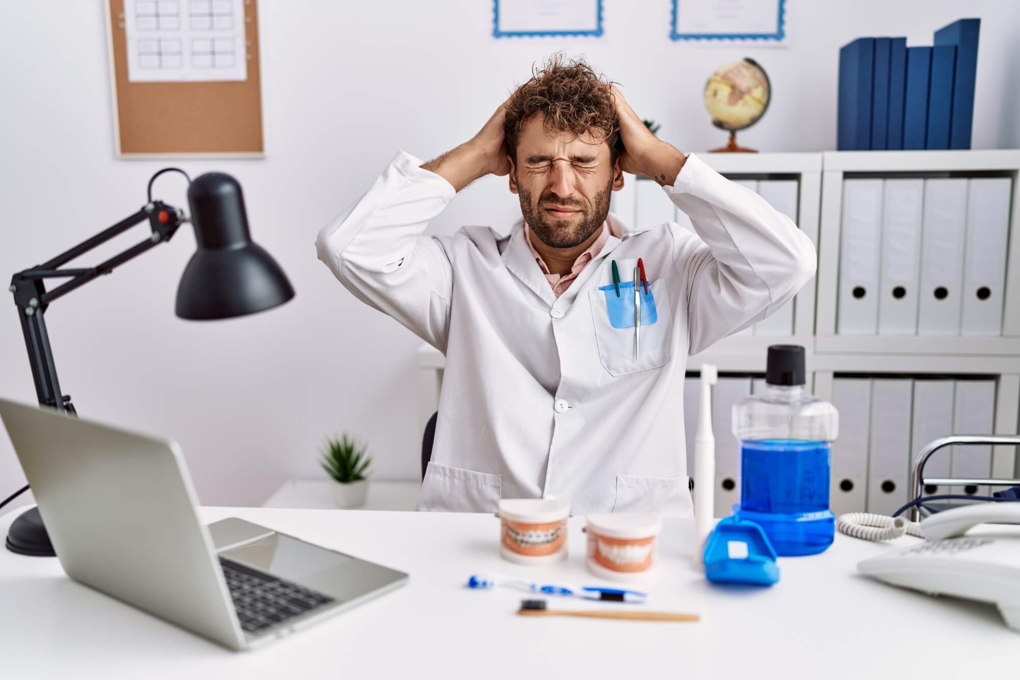 stressed dentist sitting on his work desk