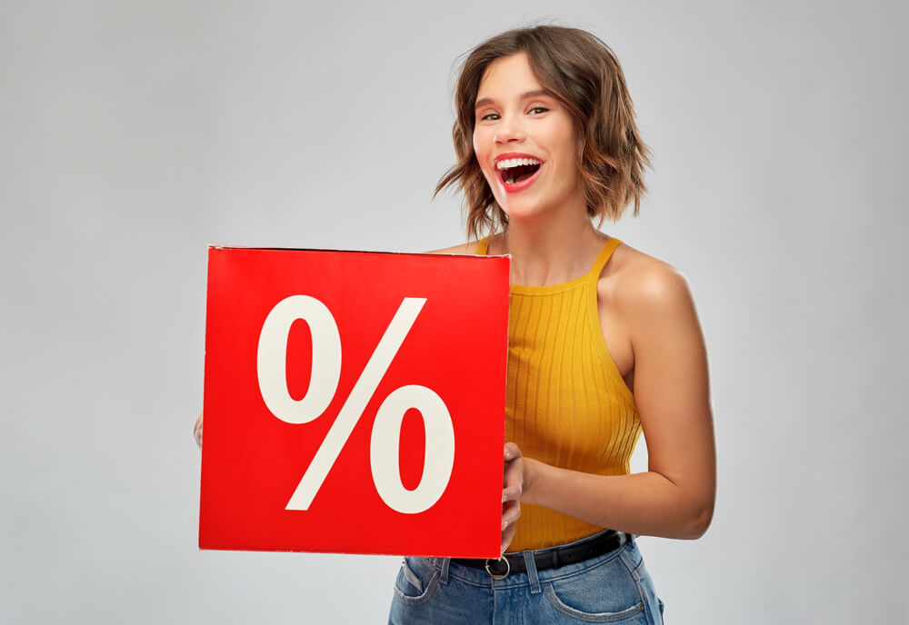 female customer happily holding a sale sign
