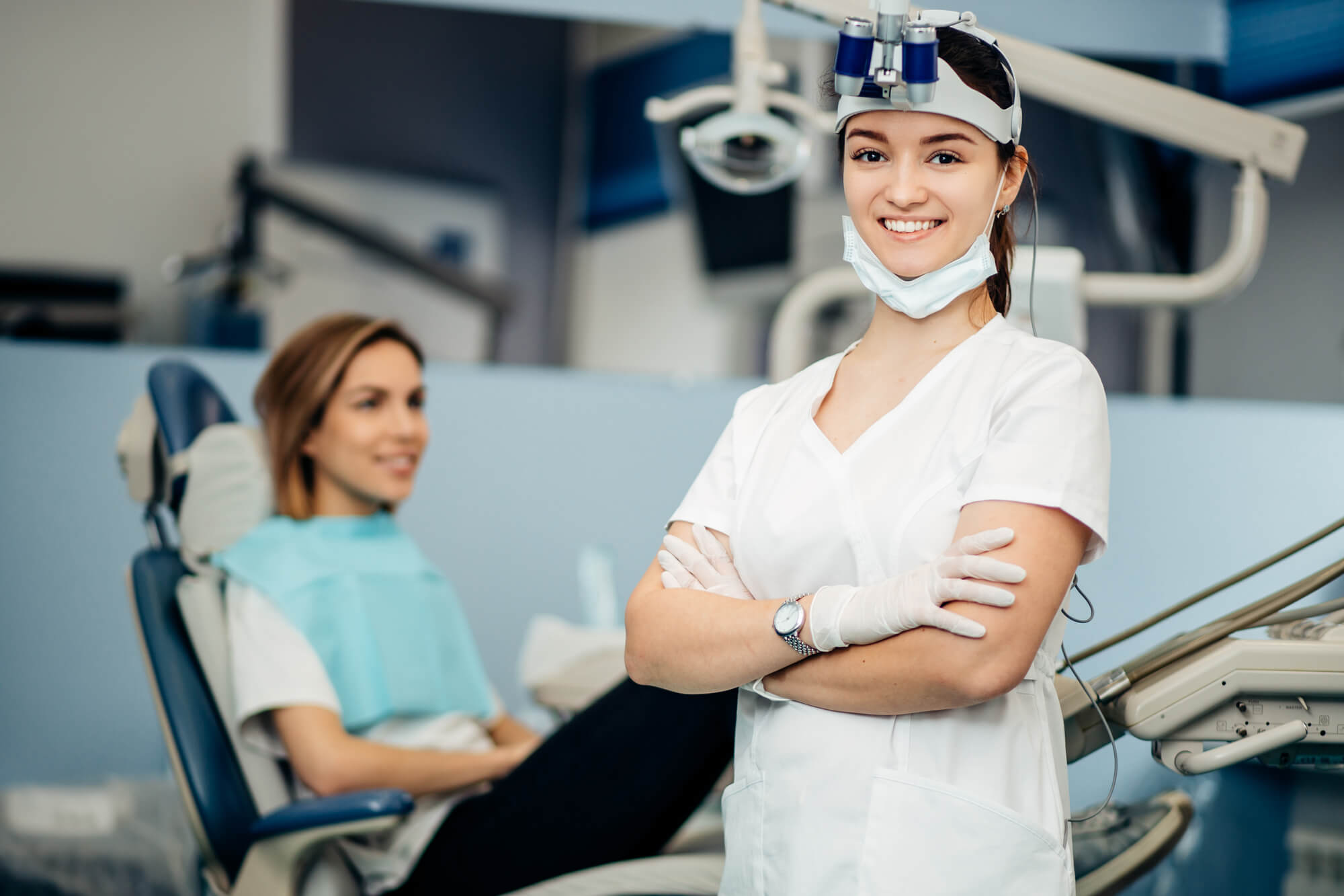 young female dentist posing with a smile in front of patient