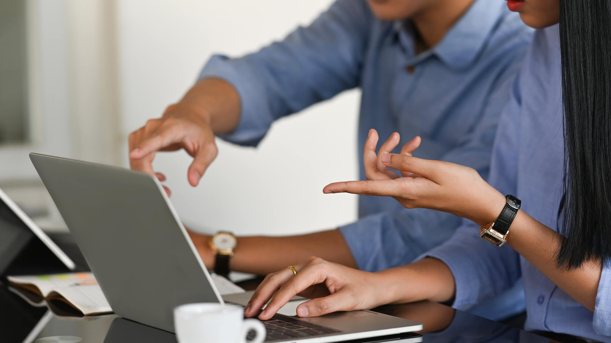 manager guiding team member on laptop