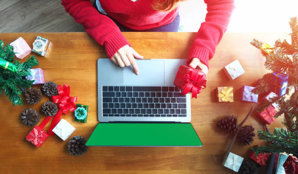 marketer working on laptop surrounded by holiday ornaments