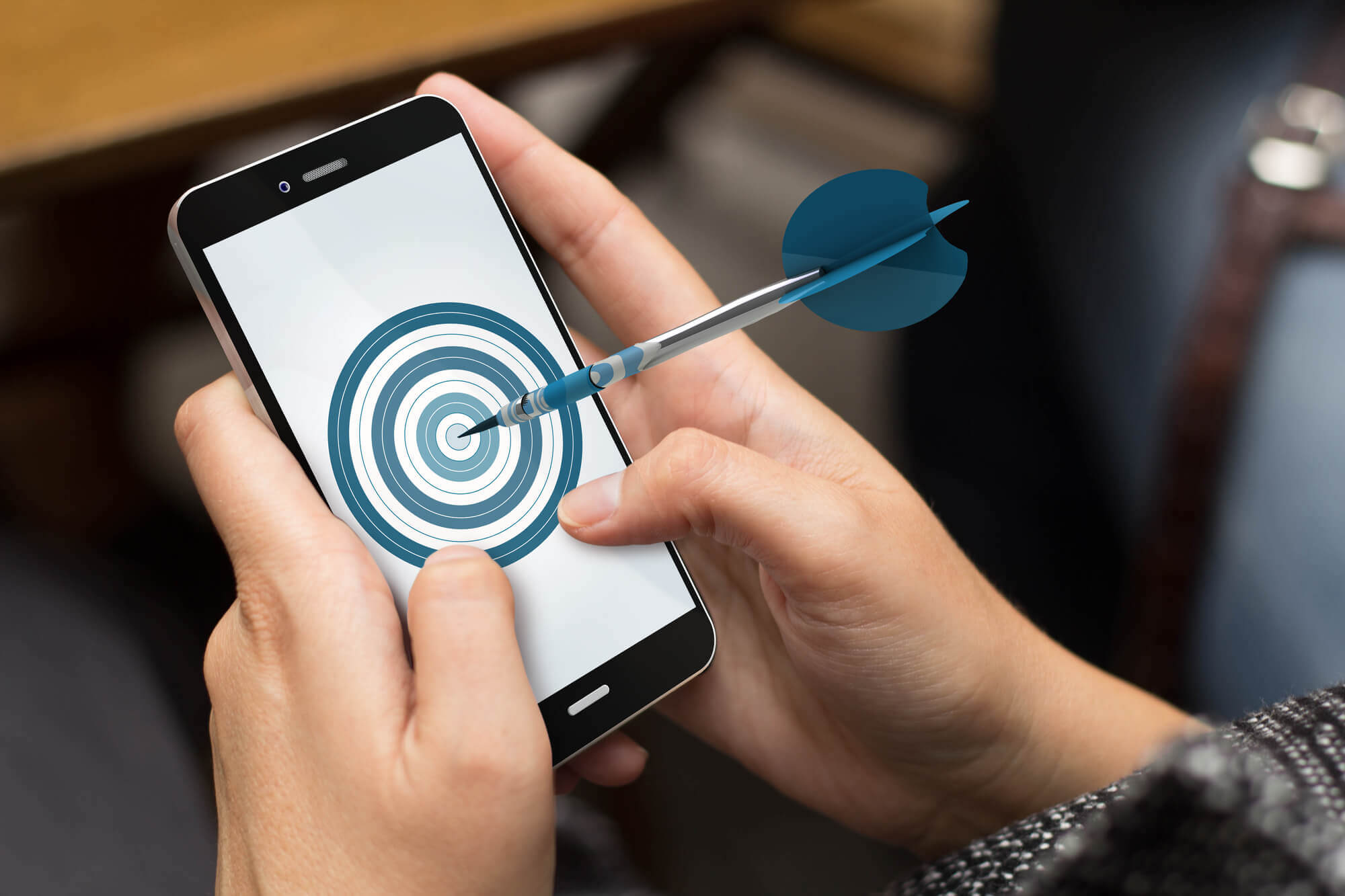 woman holding a phone with a dart hitting the screen digital marketing 