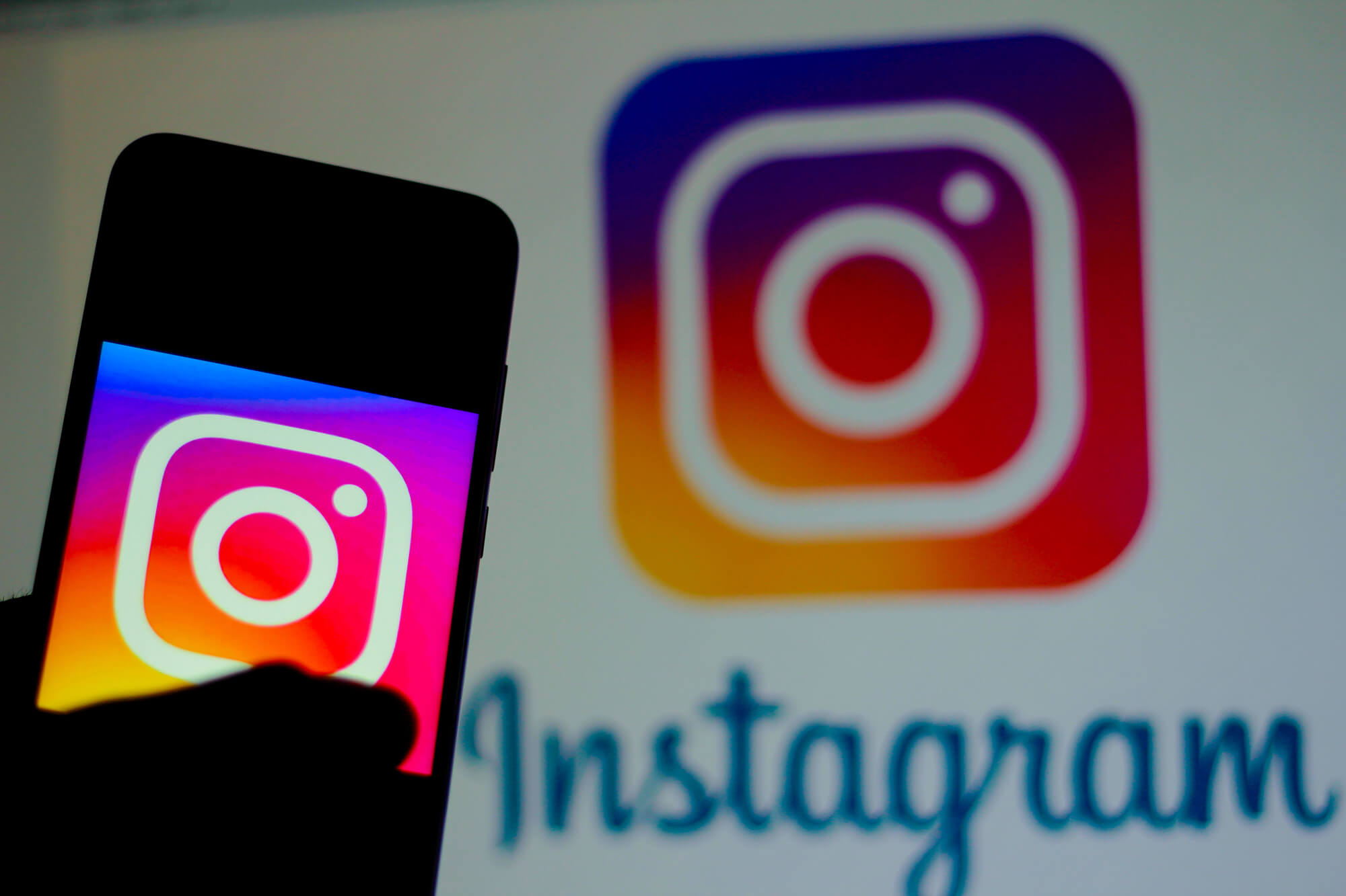 instagram logo on phone screen with another instagram logo on the background social media marketing