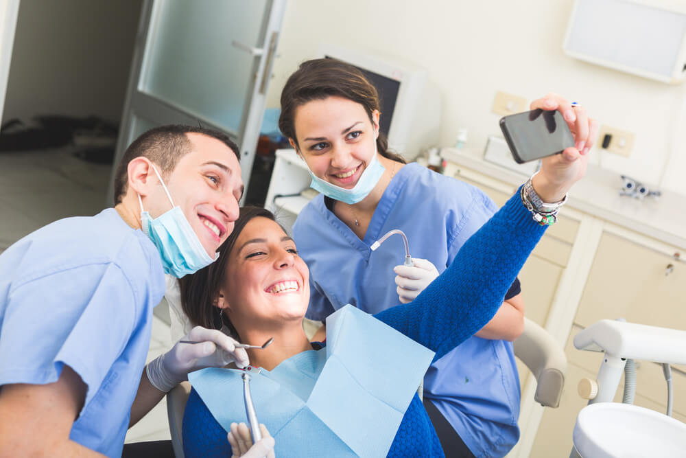 patient taking a selfie with dentist and hygienist dental social media marketing