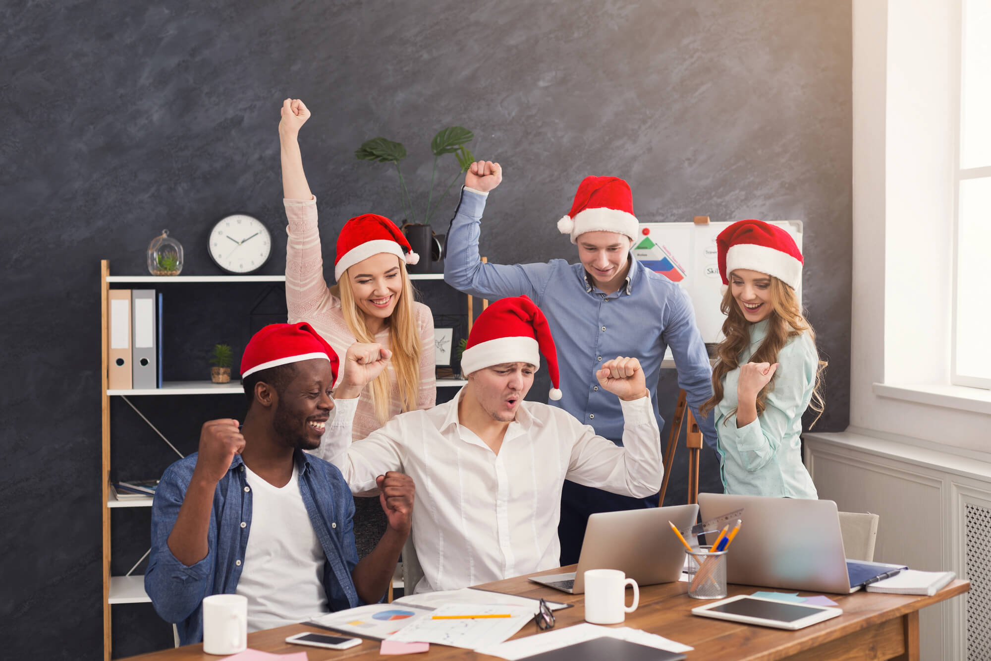 marketing team members wearing santa hats celebrating success