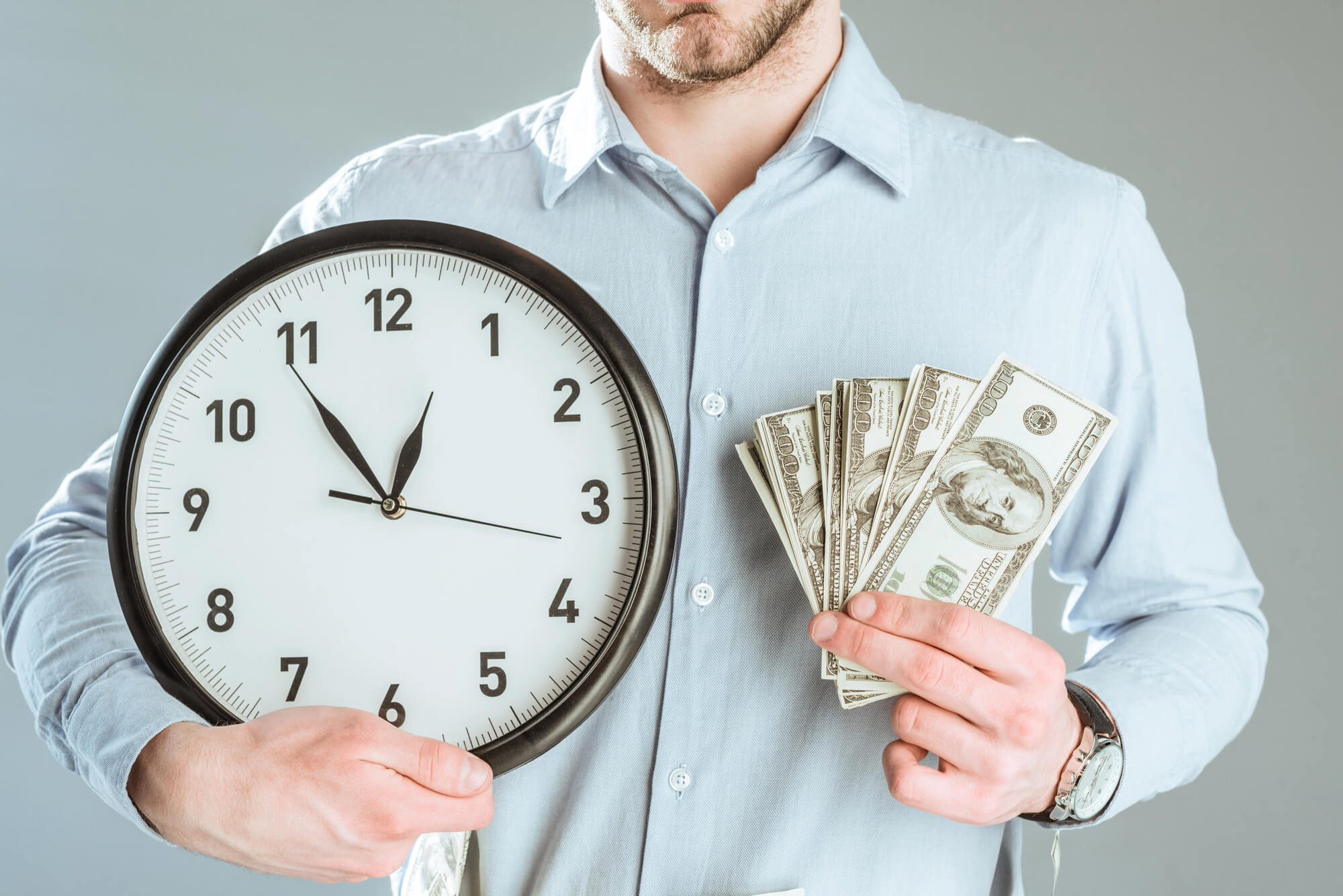 businessman holding clock and money