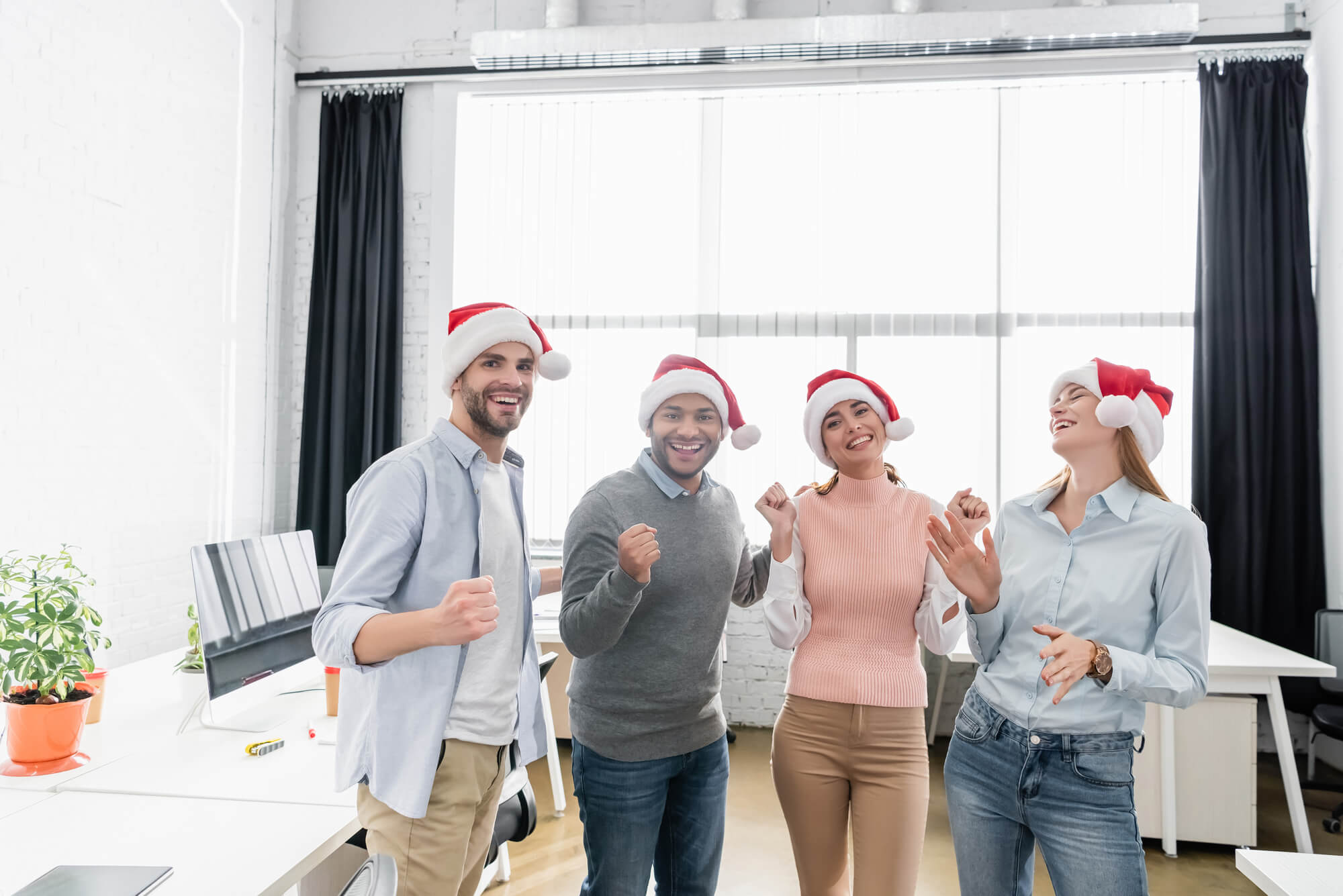 sales team members with santa hats celebrating a win