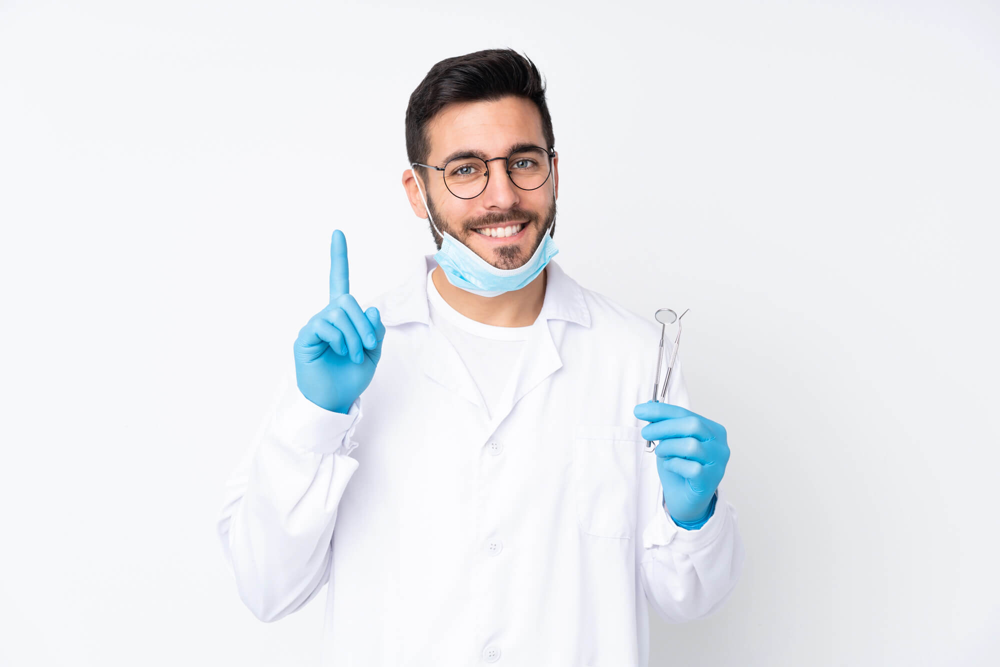 smiling dentist holding dental tools and gesturing with one finger up