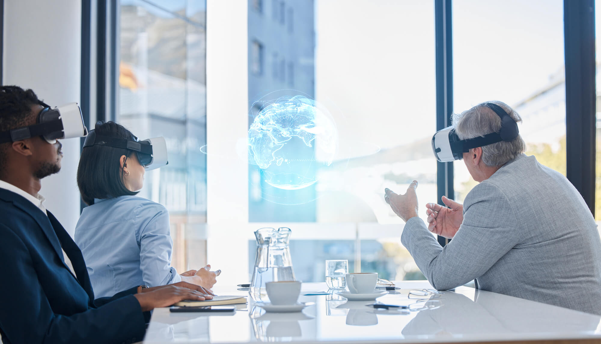 business professionals using VR headsets in a meeting, interacting with a holographic globe projection