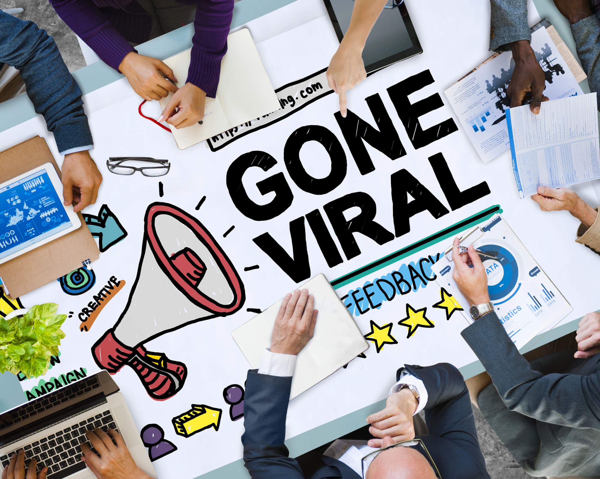 team collaborating on a 'Gone Viral' marketing poster with illustrations and data charts