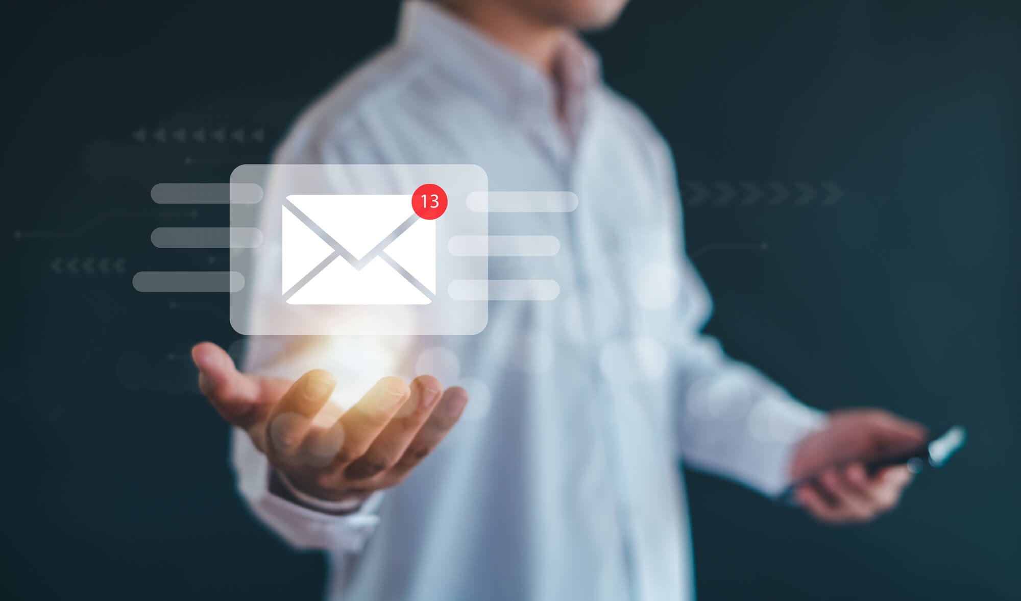 person holding a phone with an email icon showing 13 unread messages