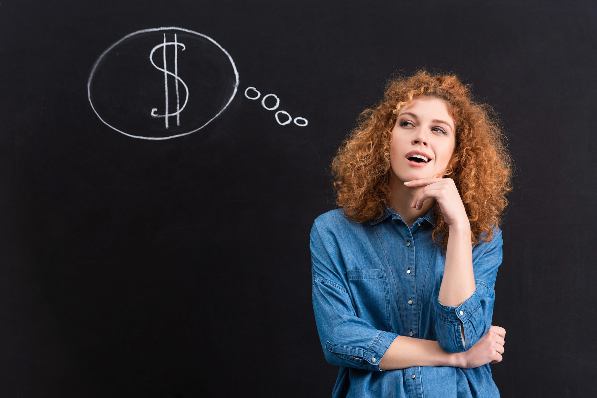 curious woman standing in front of a chalkboard with a dollar sign drawn in a thought bubble