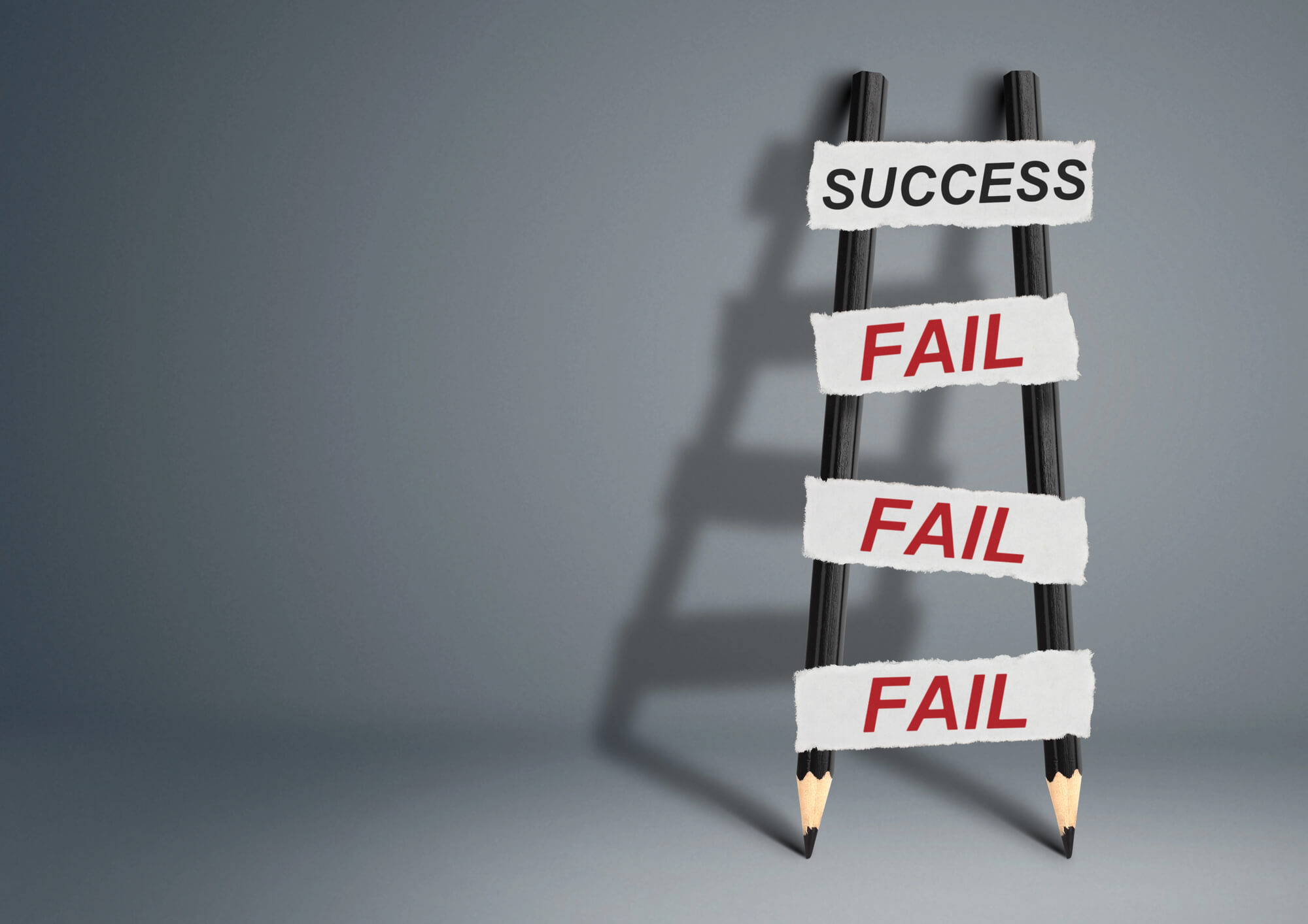  A ladder of pencils with "FAIL" steps leading to "SUCCESS"