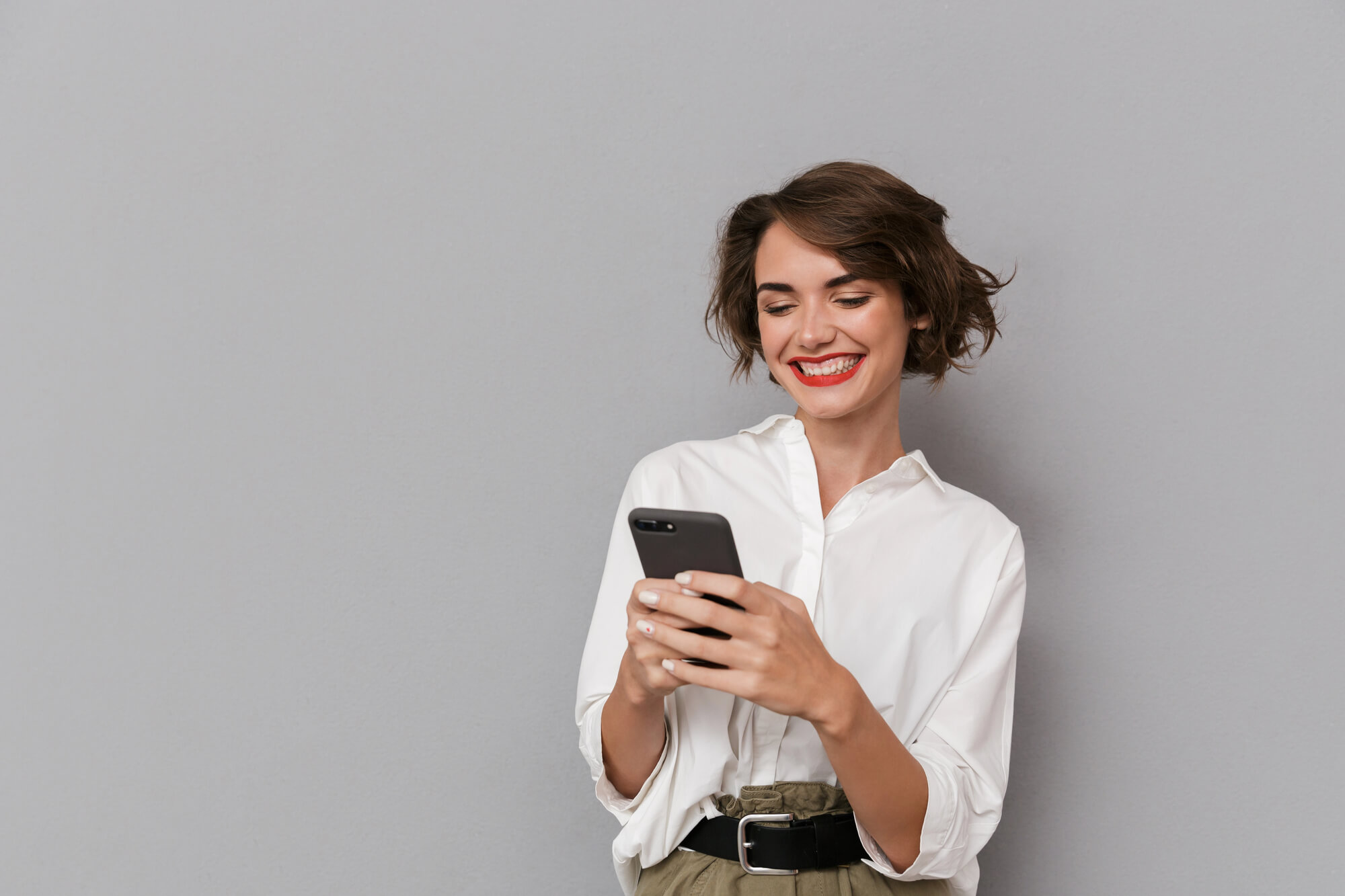 Woman smiling as she watches a video on her phone