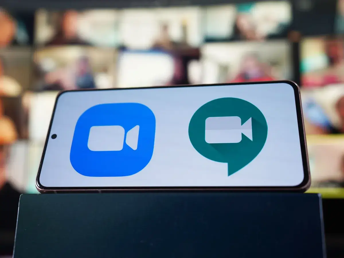phone displaying side by side logos of zoom and google meet