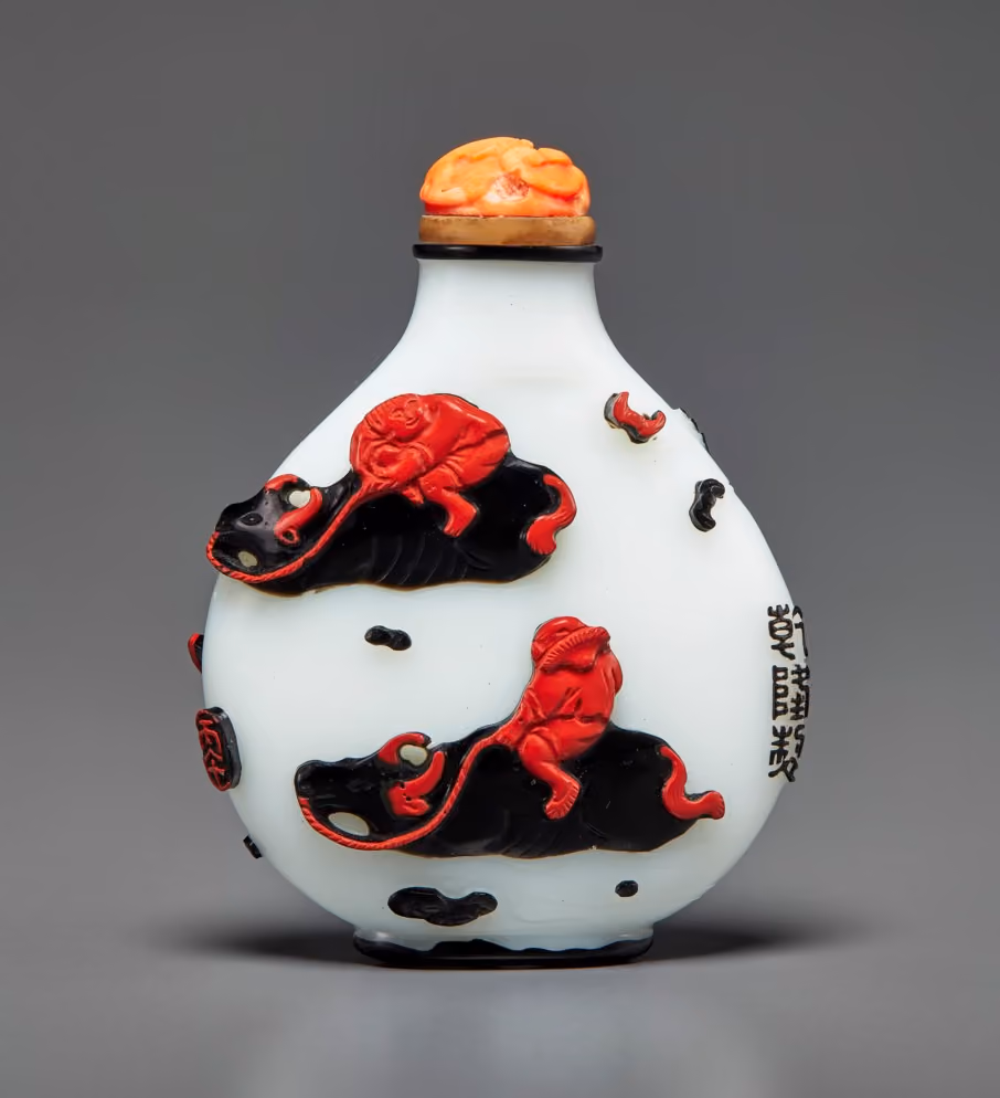 Red and black overlay glass with boys on buffalos and fishermen