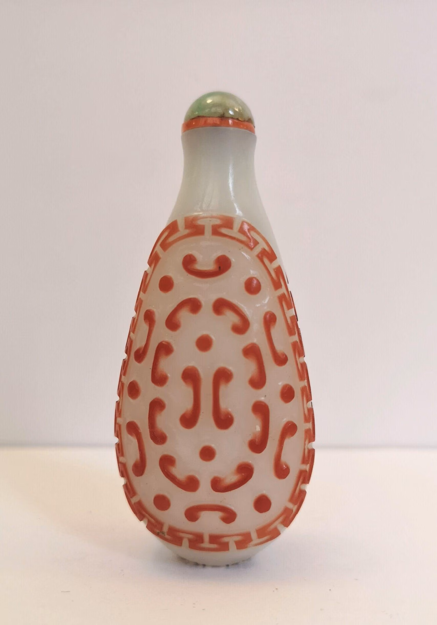 Imperial red overlay on white glass with archaic scrolls