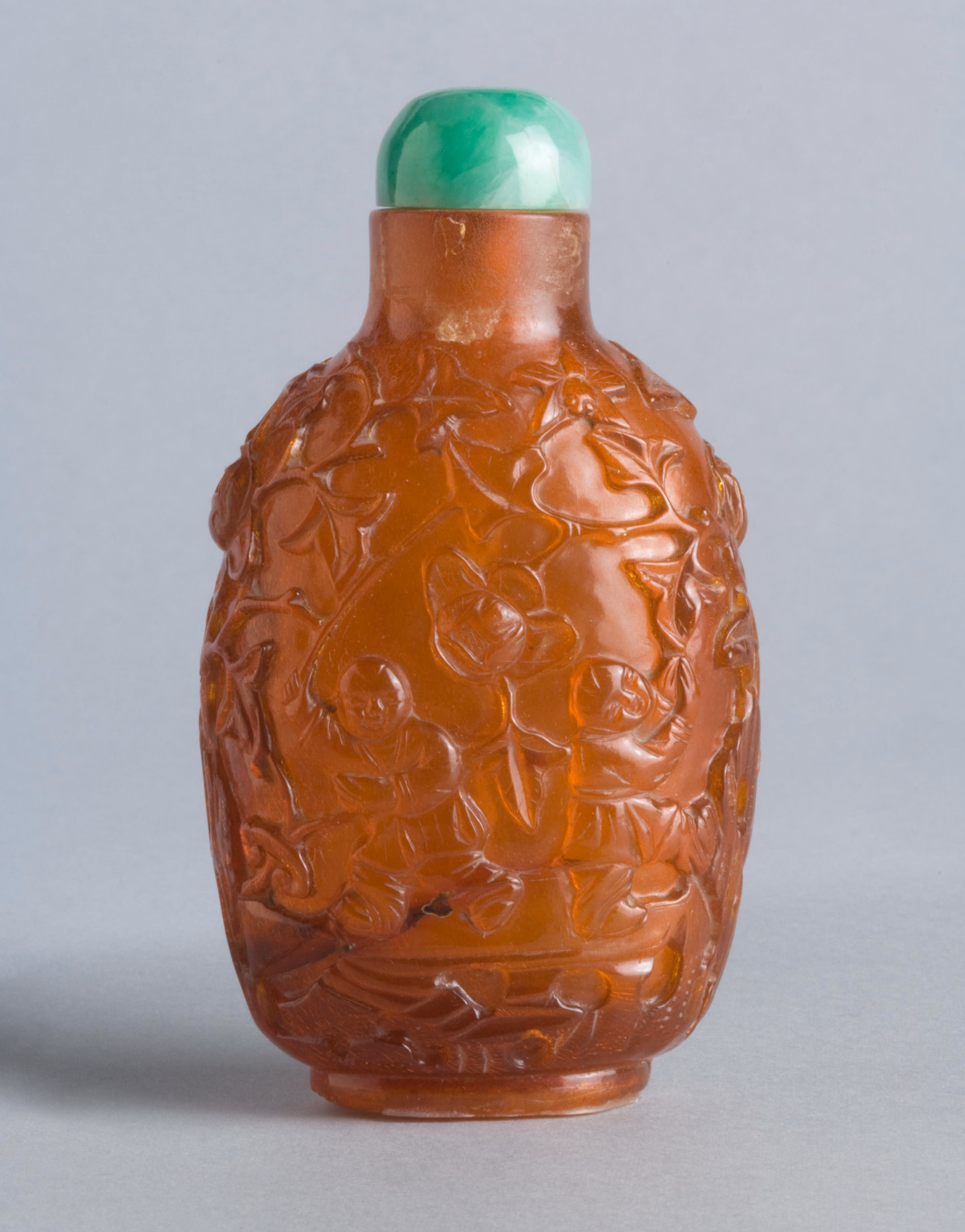 Amber carved with boys, flowers and fungus
