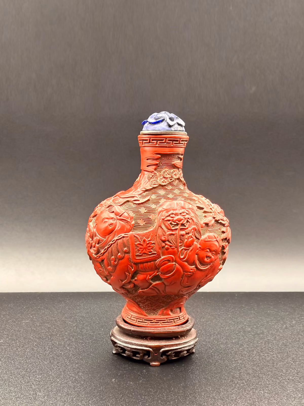 Cinnabar lacquer of flattened baluster form with boys and Buddhist lion