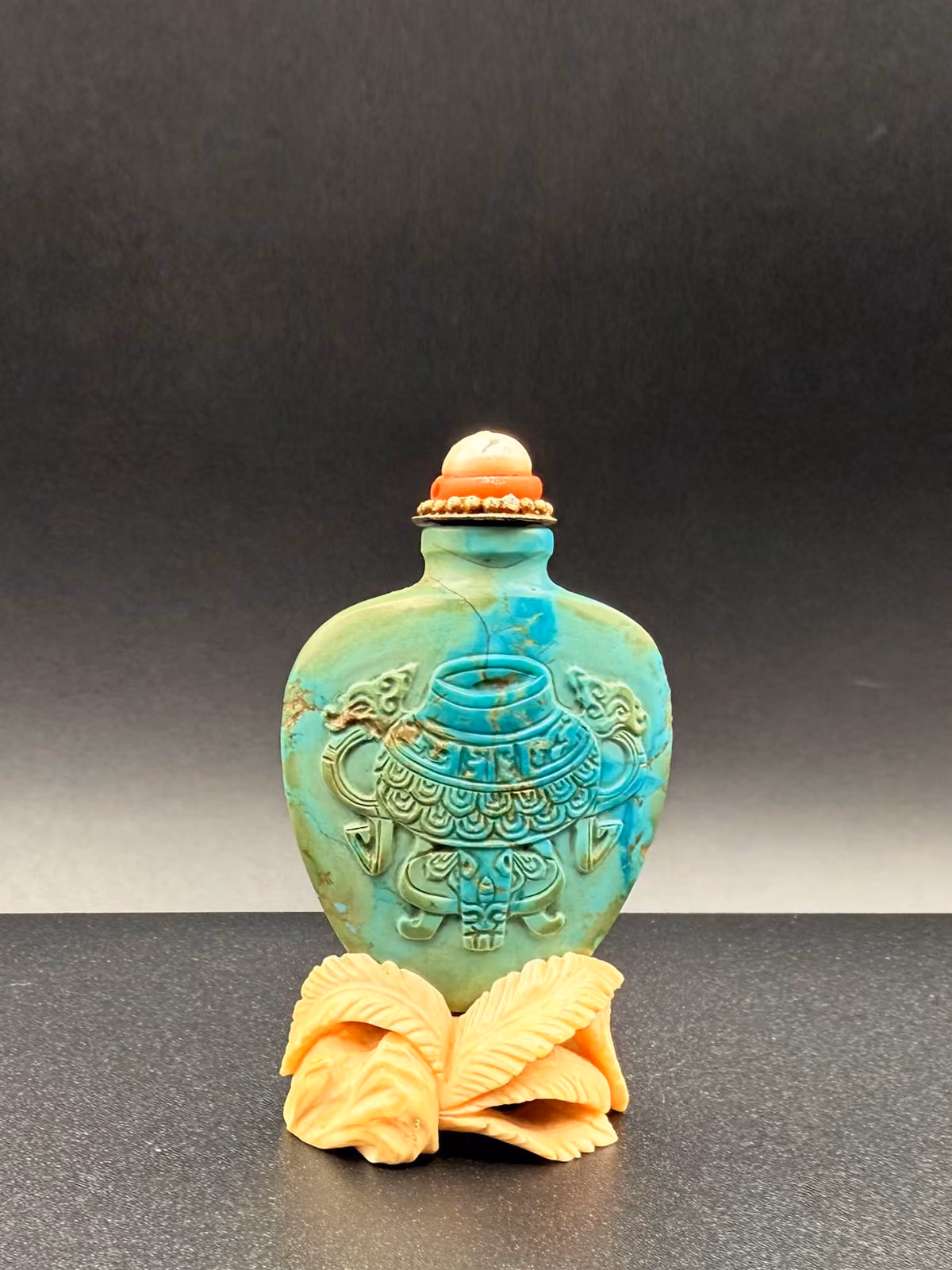 Turquoise of spade form with archaic bronze and inscription