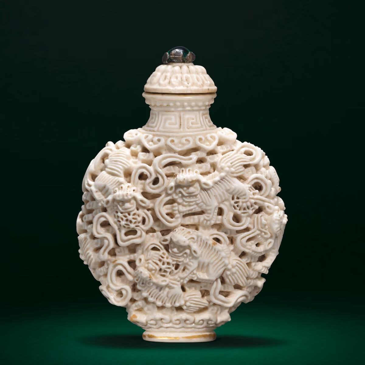 Reticulated porcelain snuff bottle depicted Buddhist lions with brocade balls at play