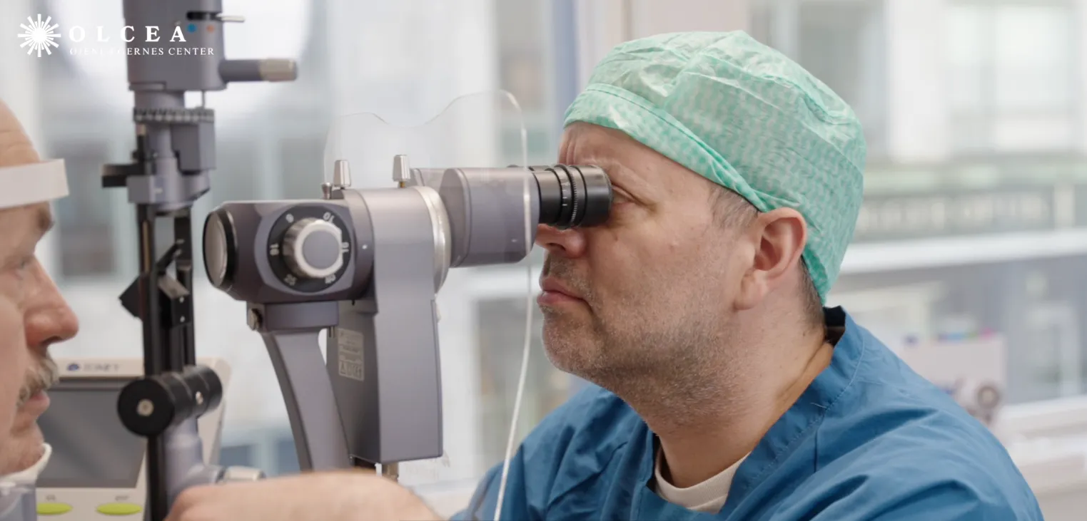 Øjenlæge undersøger patients øje med en spaltelampe i klinik.