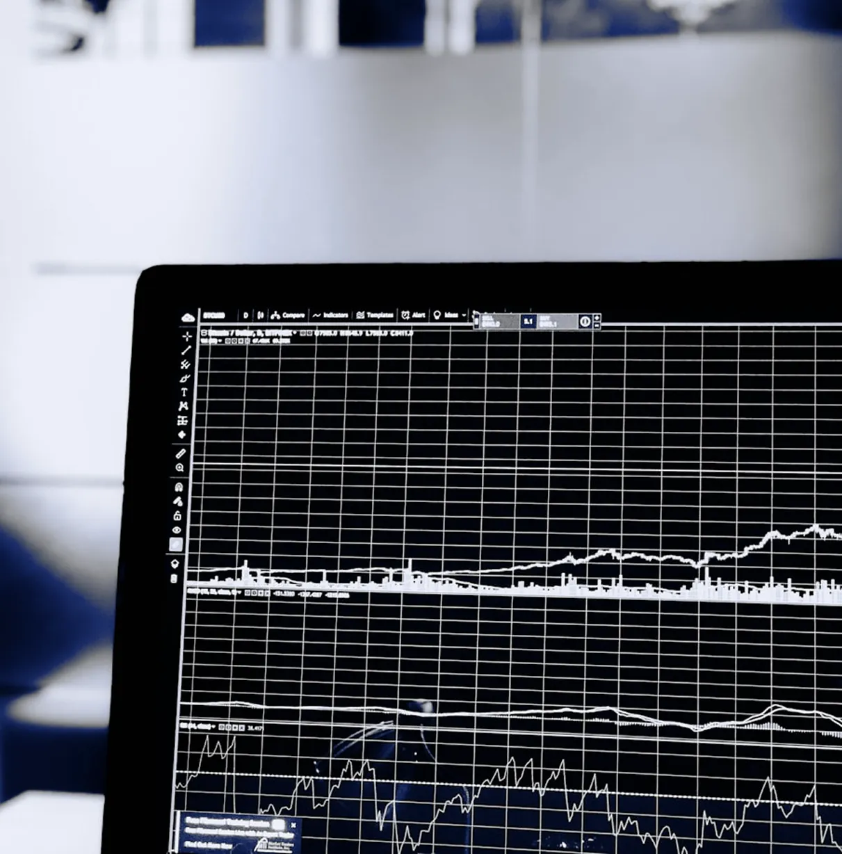 Laptop screen showing financial market charts and data graphs.