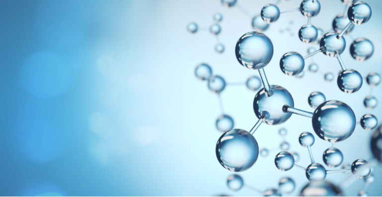 Close-up of clear water splashing with droplets in motion against a blurred background.