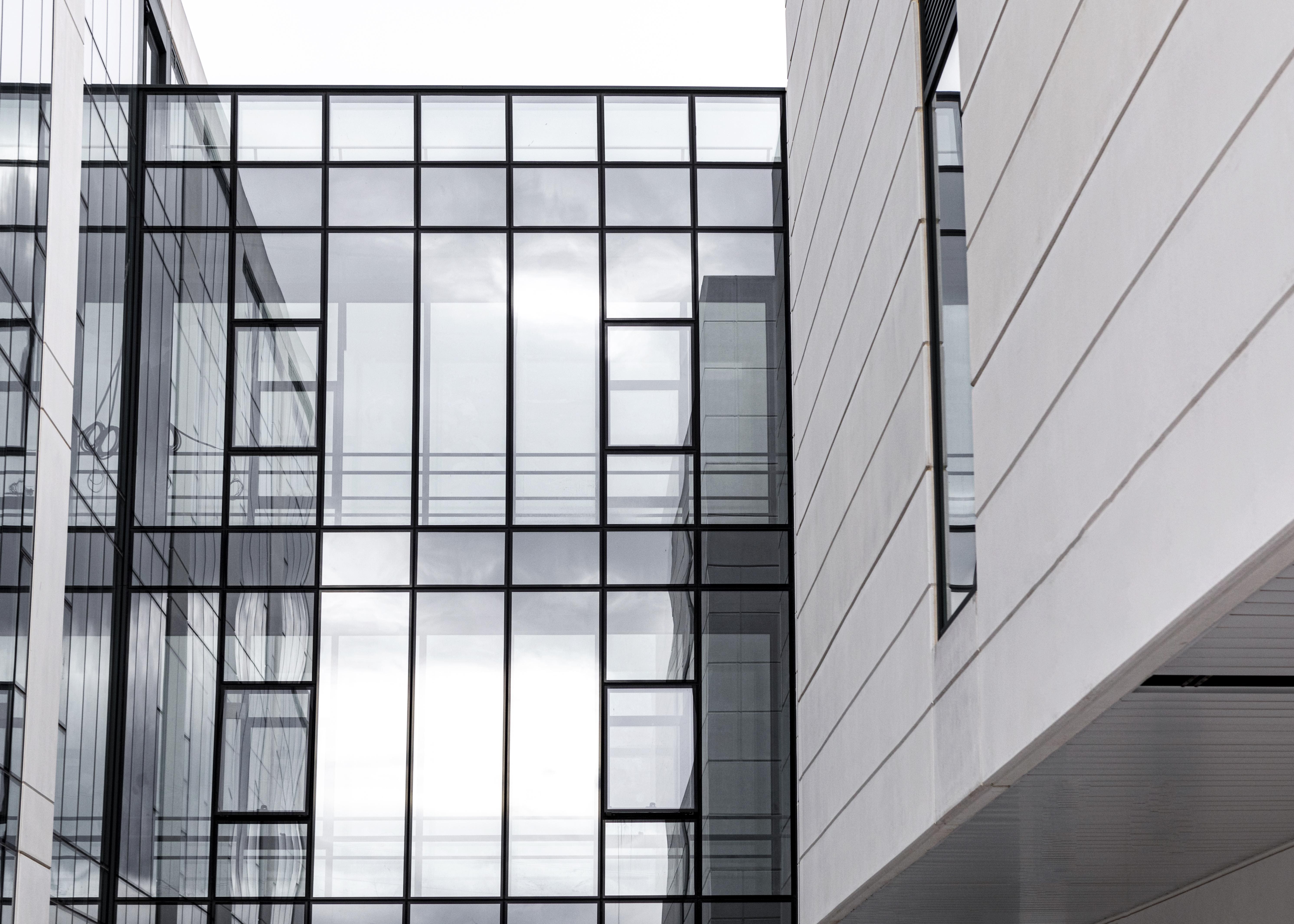 Modern apartment building with large grid-style glass windows and white exterior panels