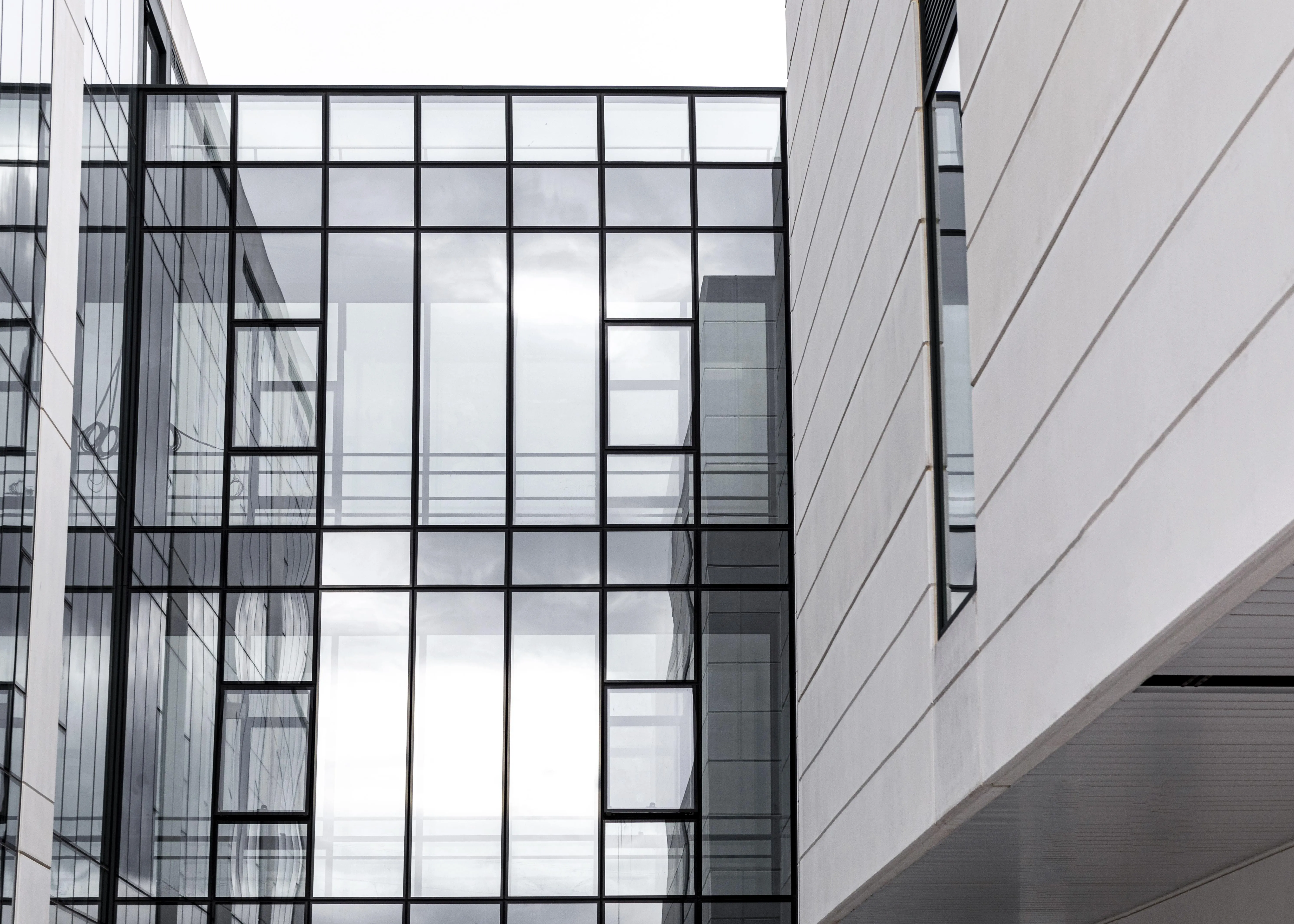 Modern apartment building with large grid-style glass windows and white exterior panels