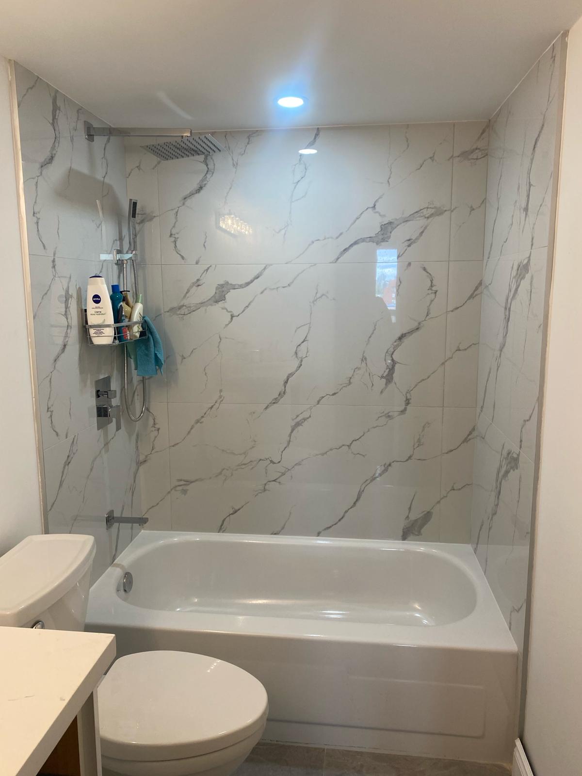 Custom glass shower enclosure with black marble tile.