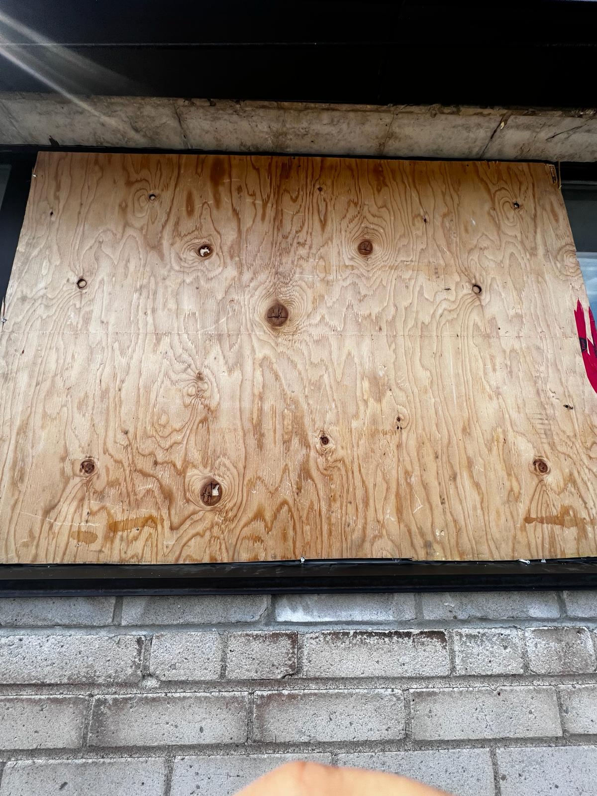 Commercial window board-up with plywood panel