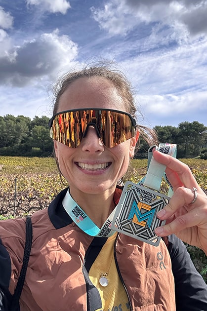 Photo d'une cliente prise lors d'un marathon. Marathon qui a été préparer en ligne avec un coach sportif : Matthieu Laurent qui est aussi kine du sport et osteo 