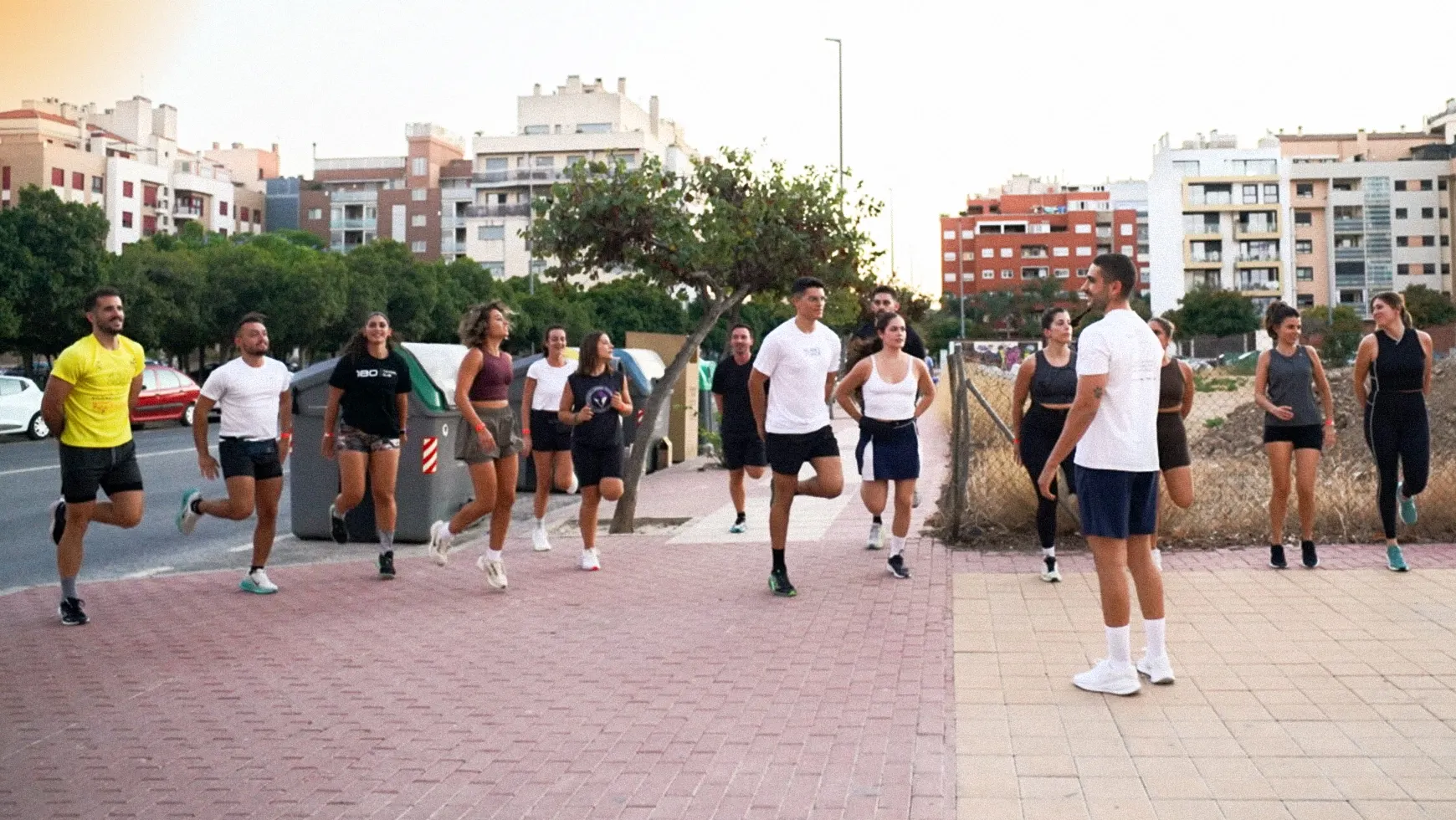 Un grupo de personas haciendo estiramientos y calentamientos antes de un entrenamiento en 180 training club