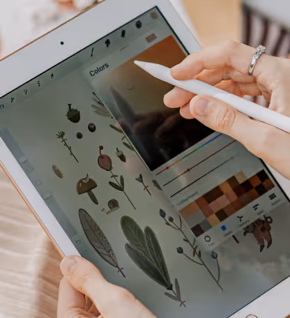 Hands drawing botanical illustrations on an iPad with Apple Pencil representing digital artwork creator content.