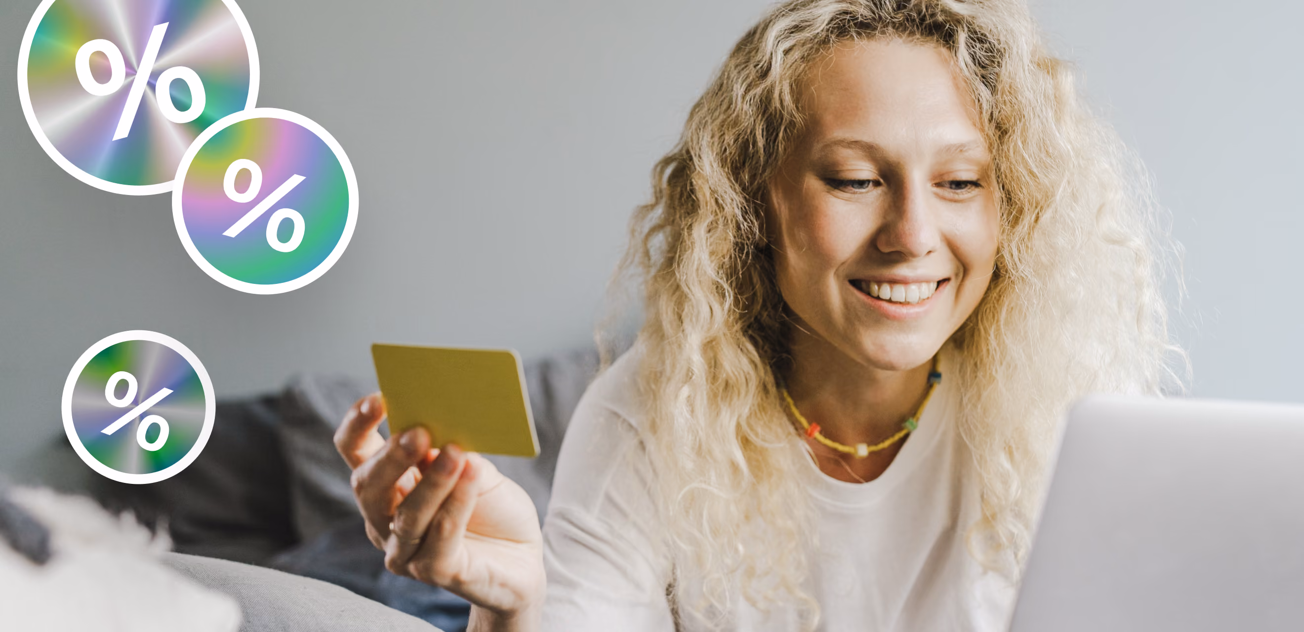 Smiling shopper holding a payment card at a laptop next to percent discount badges