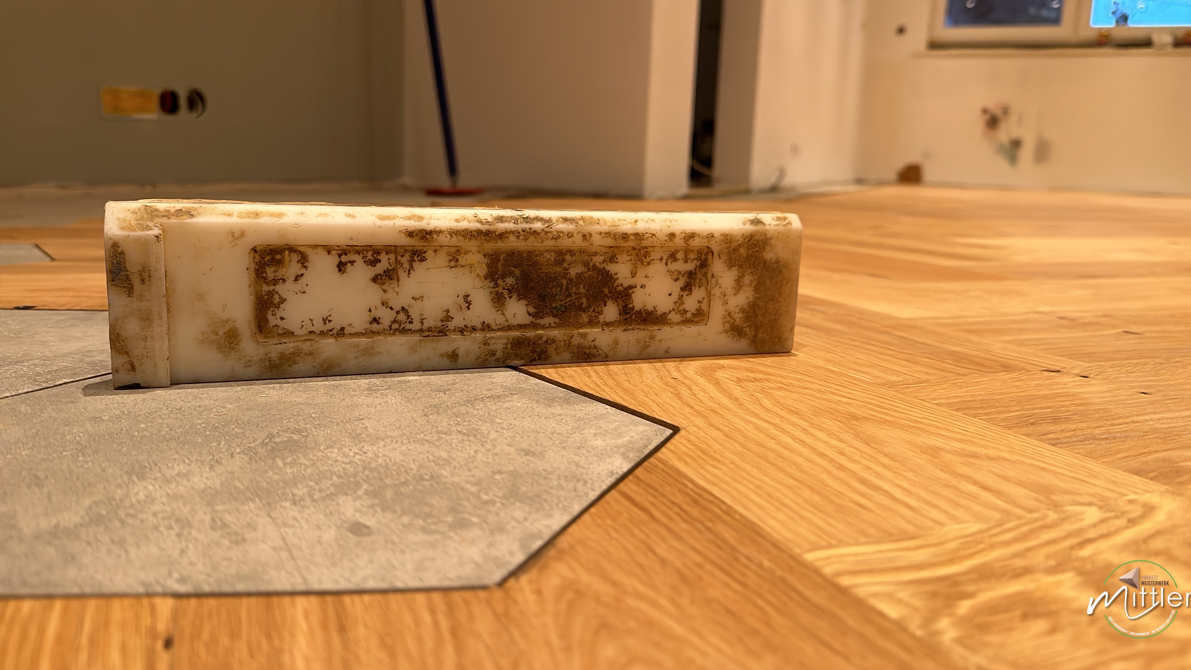 Detailarbeit bei der Parkettverlegung: Sauberer Übergang von Eichenparkett zu Fliesen in Hennef.