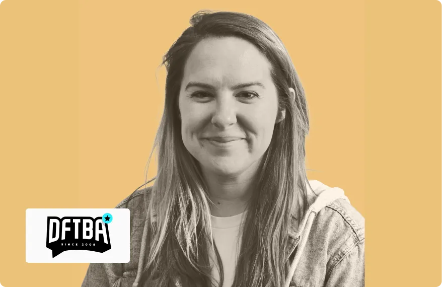 Smiling woman with long hair wearing a denim jacket against a solid mustard-yellow background.