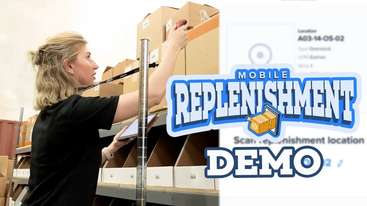 Woman scanning boxes on warehouse shelves for mobile replenishment with tablet and scanner.