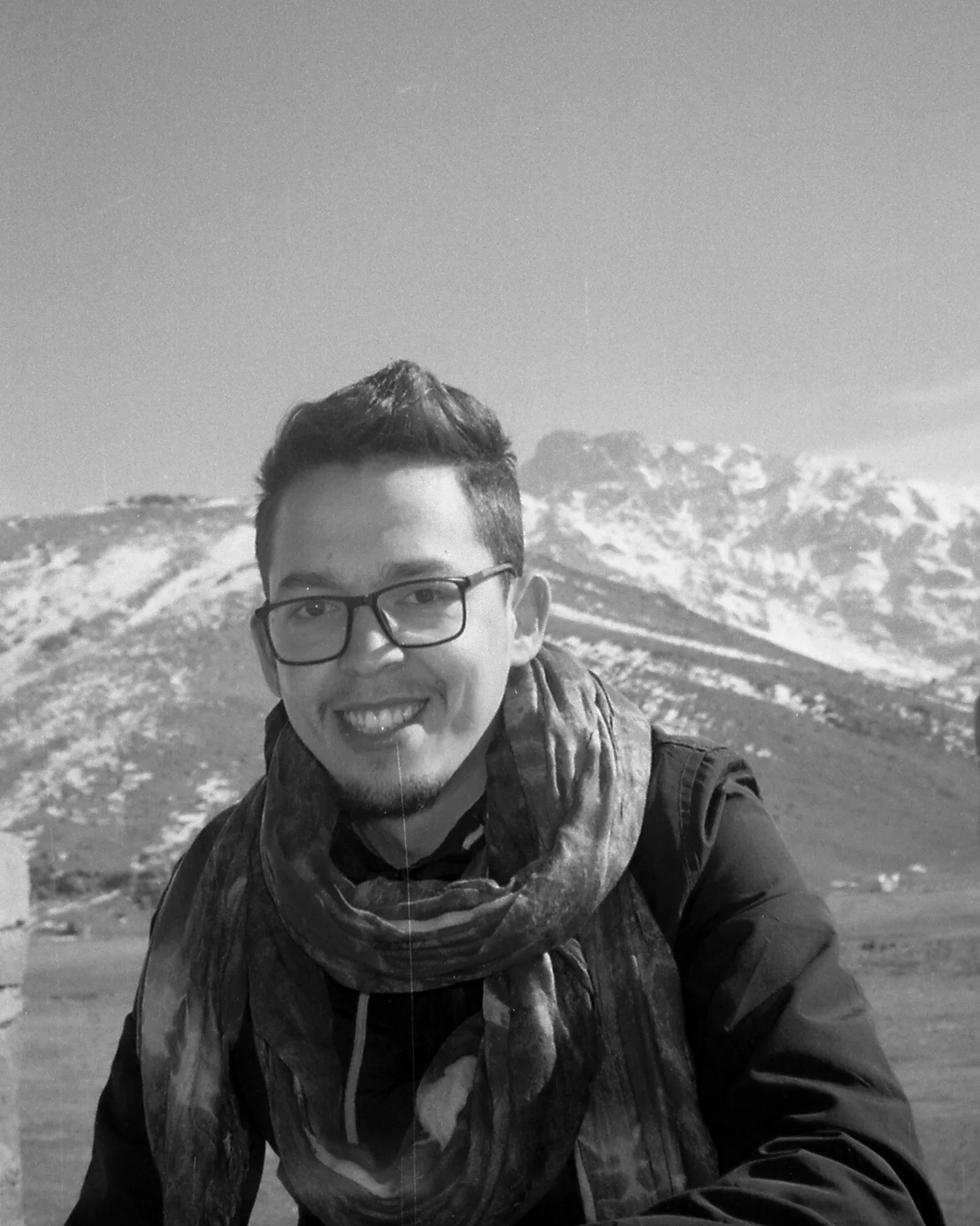 Zakaria Ouaghad, photographe et vidéaste marocain, membre de l’équipe de Touda Ecolodge dans la vallée des Aït Bougmez, avec les montagnes enneigées du Haut Atlas en arrière-plan.