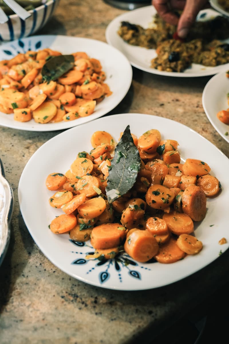 Carottes mijotées aux herbes fraîches sur assiette décorée dans la cuisine de Touda ecolodge