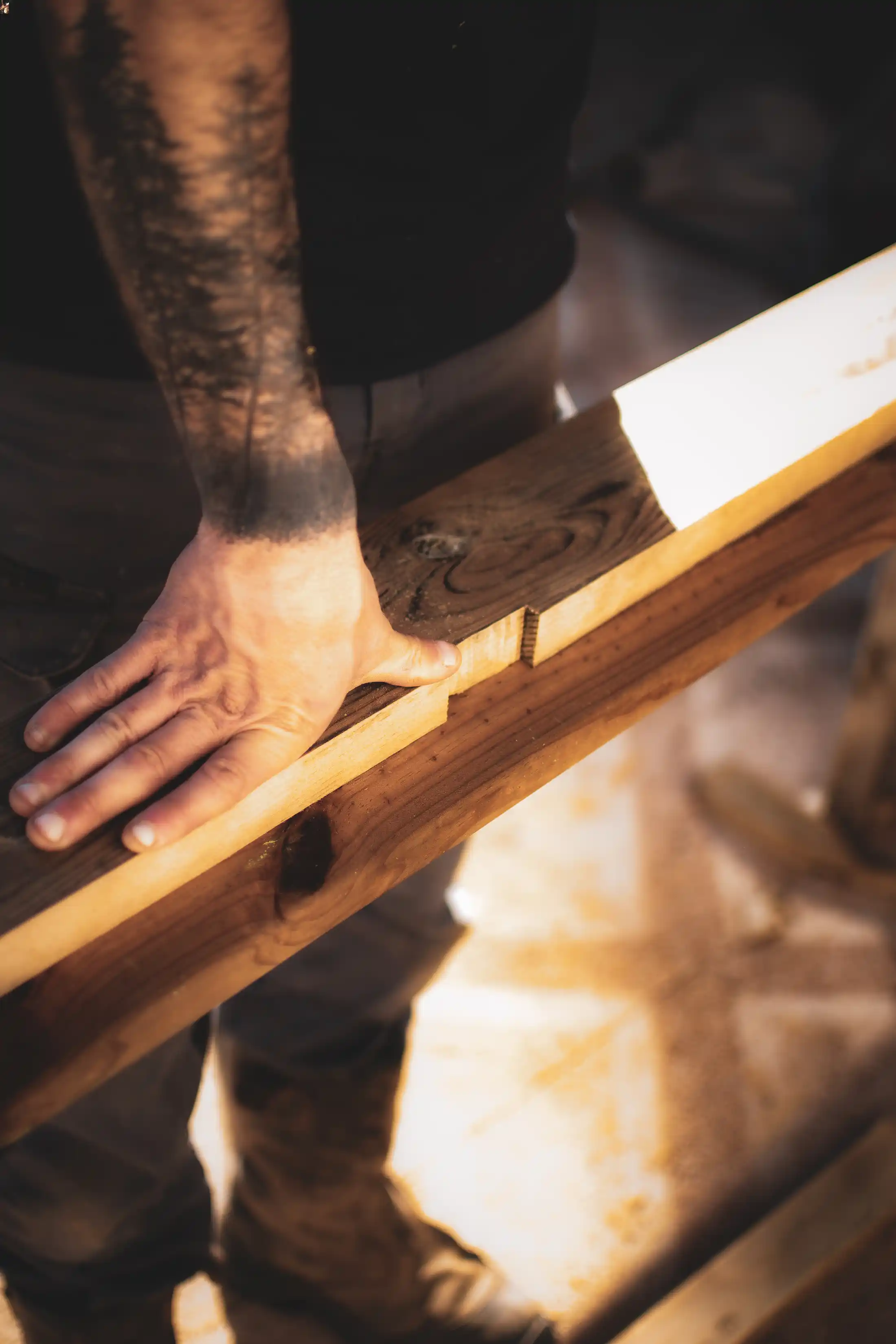 Maçon qui prépare une planche de bois pour une terrasse de Dordogne