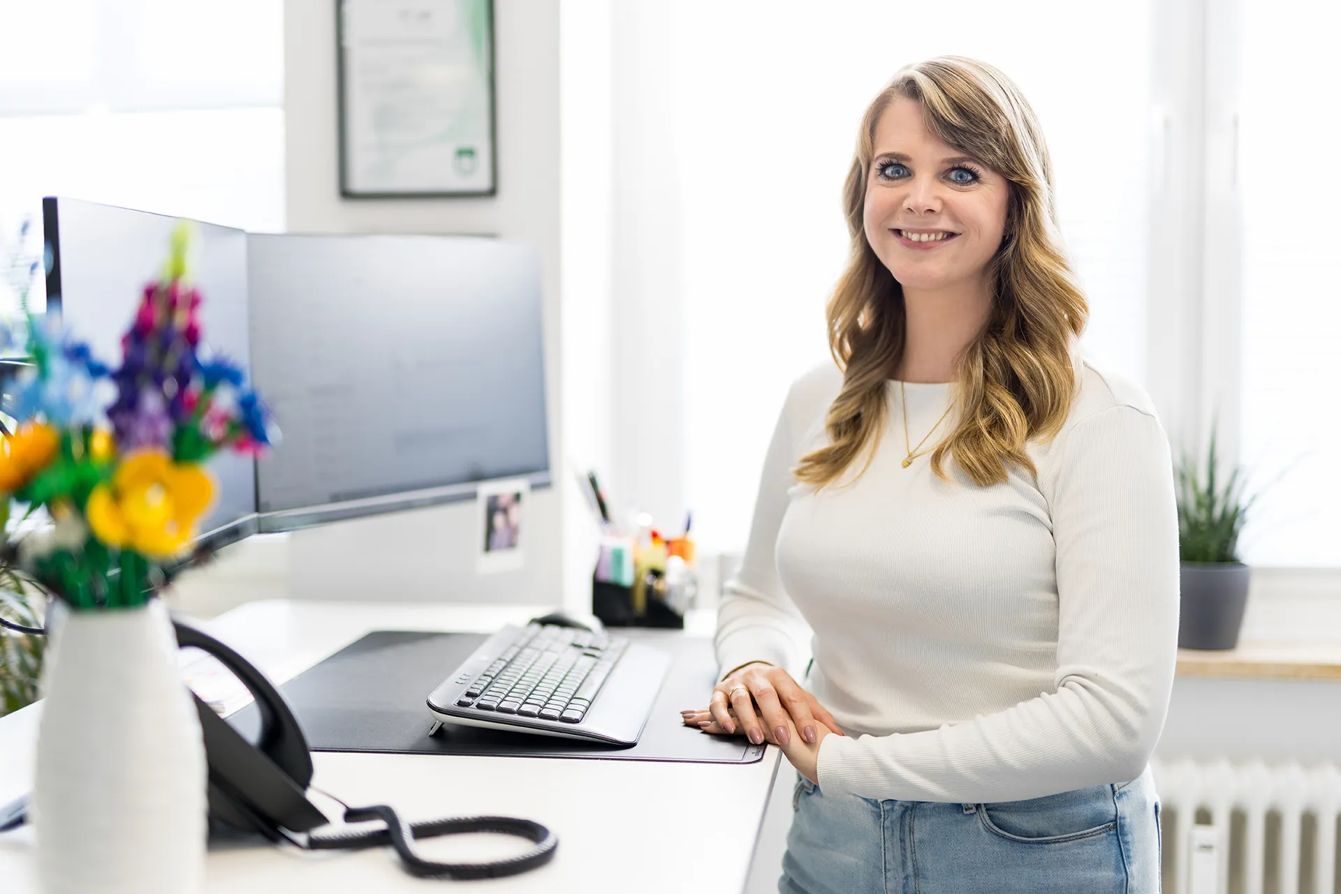 Die Mitarbeiterin Marie Ziemba steht am Schreibtisch in den Geschäftsräumen der Schremper IT GmbH in Wuppertal.