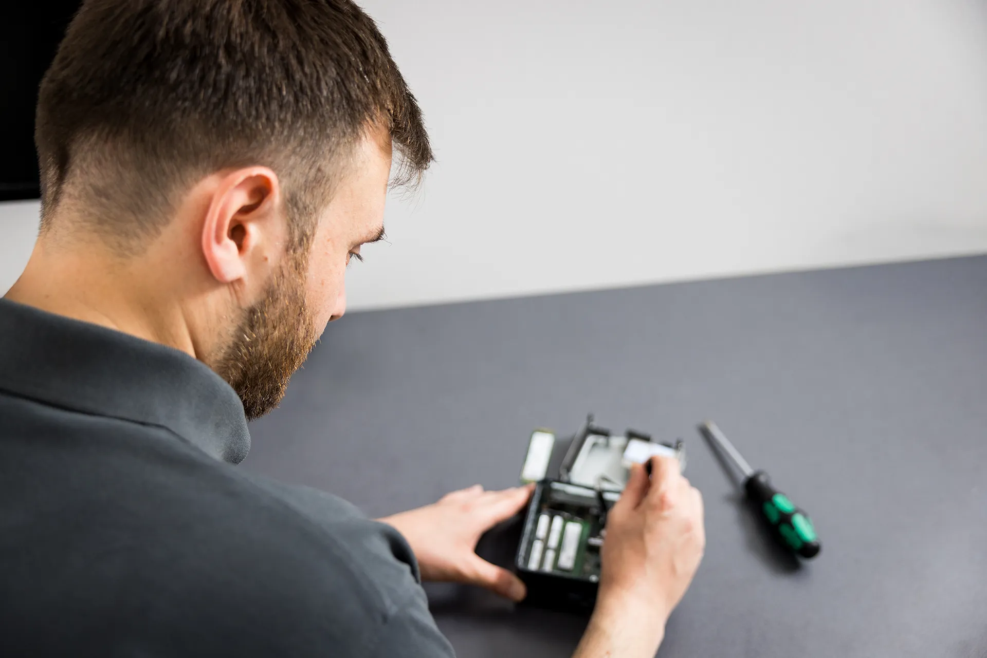 Ein Mitarbeiter der Schremper IT GmbH repariert Hardware in der Werkstatt in Wuppertal.