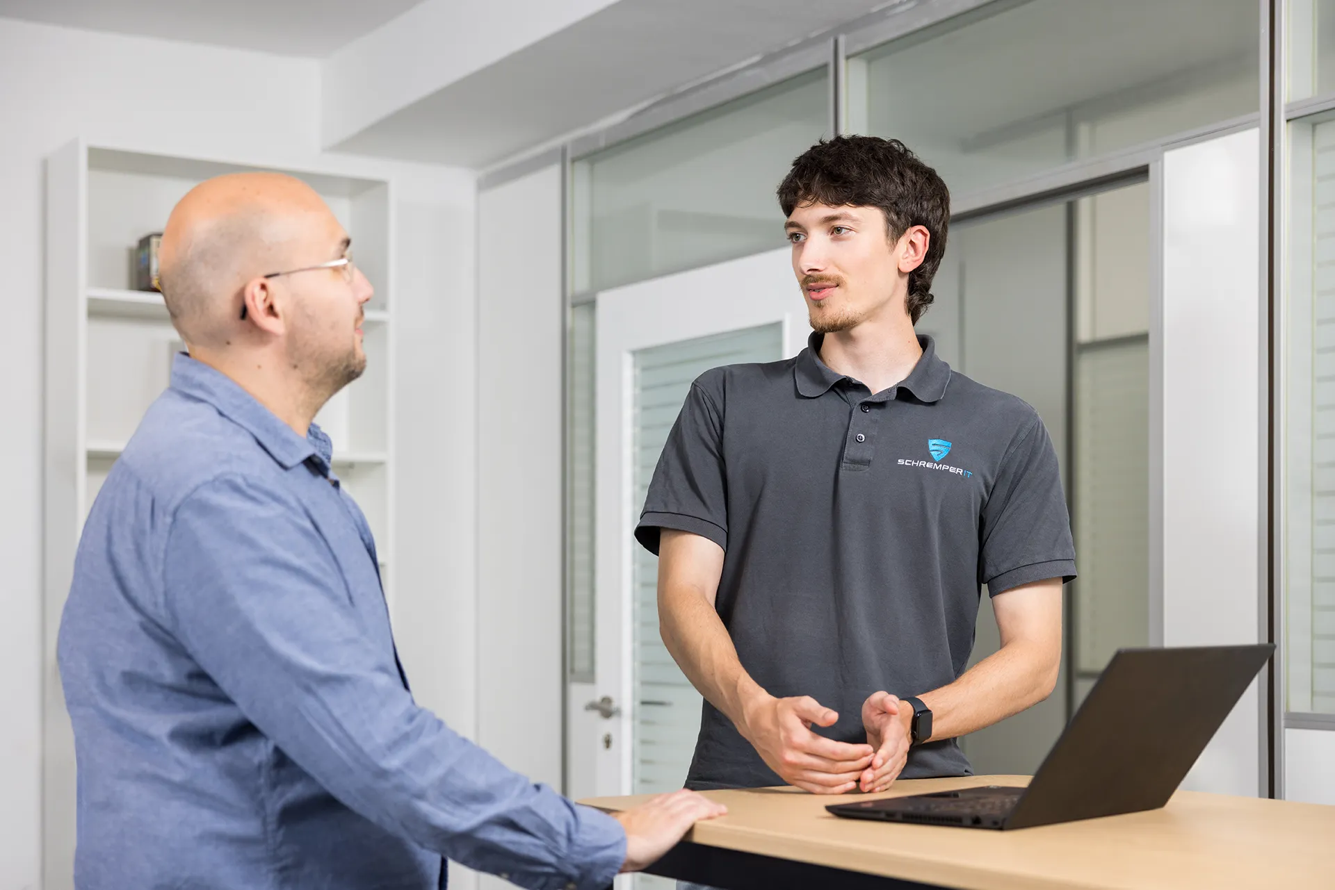 Geschäftsführer Stefan Schremper und ein Mitarbeiter diskutieren über die digitale Souveränität von Unternehmen in Wuppertal.