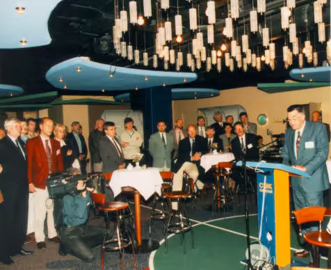 Groep mensen is aanwezig bij presentatie in 1996